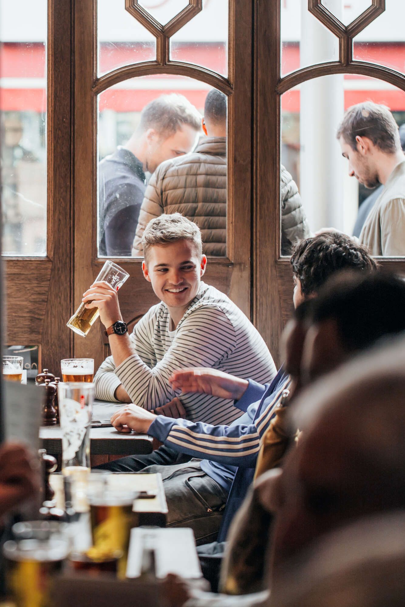 Man smiling while drinking a pint